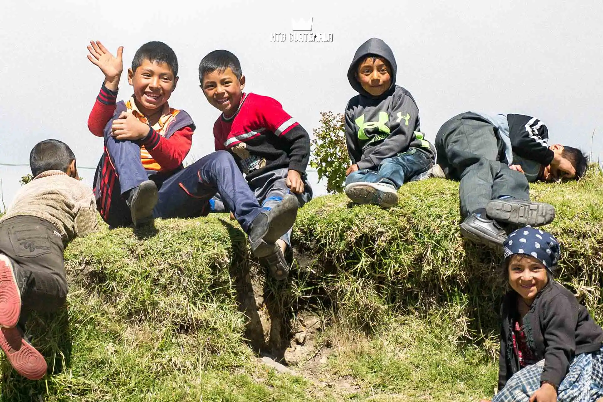 Children wave and cheer for cyclists during the Travesia Campanabaj. Totonicapán, Guatemala